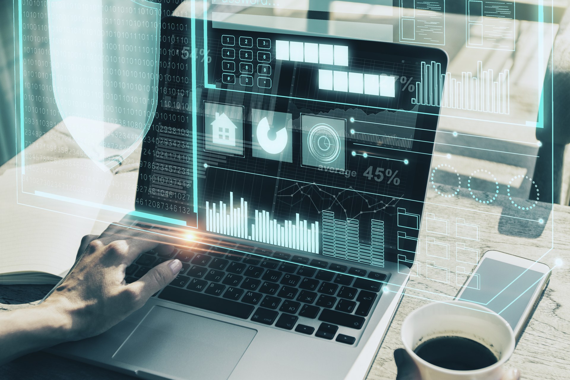Hands working on a laptop with digital business analytics overlays